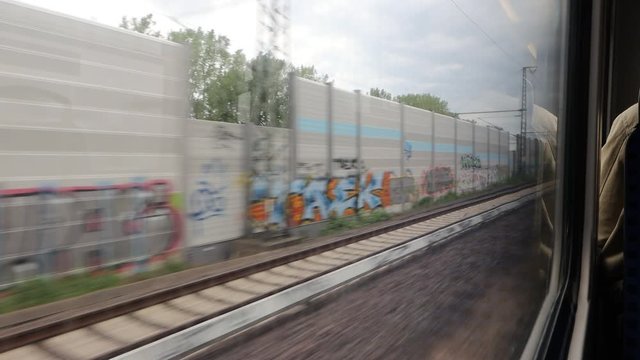 The view Through dirty Window of a moving commuter train in Hamburg  on the fields sweeping outside the window