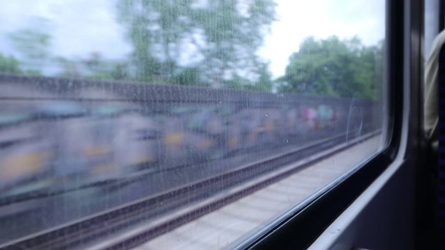 The view Through dirty Window of a moving commuter train in Hamburg  on the fields sweeping outside the window