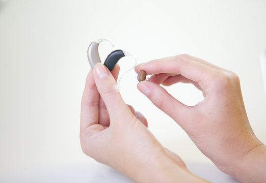 Three different hearing aids in female hands