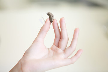 Very small hearing aid in a female hand