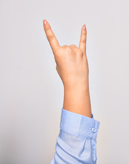 Hand of caucasian young woman doing rock sign with horns over isolated white background
