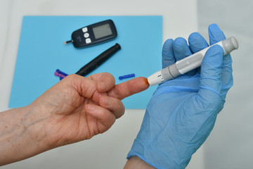 Doctor checking blood sugar level with glucometer. 