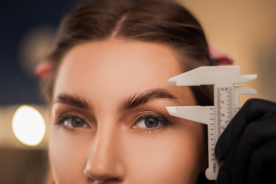 Beautiful girl master eyebrow in a beauty salon