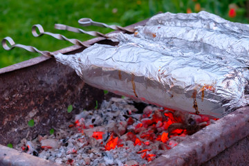  Juicy and fresh slices of pork are strung on metal skewers, wrapped in aluminum foil and grilled...
