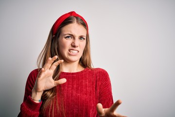 Young beautiful redhead woman wearing red casual sweater and diadem over yellow background...