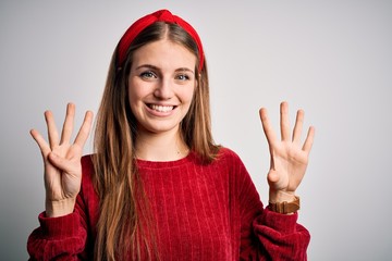 Young beautiful redhead woman wearing red casual sweater and diadem over yellow background showing...