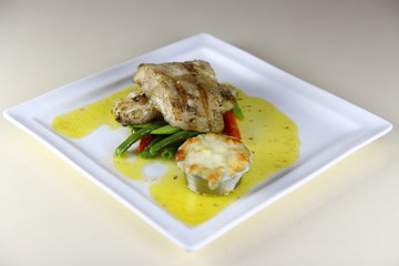 Steamed Fish Steak with Mash Potatoes and Vegies on a ceramic plate