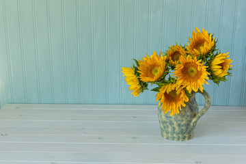 Sunflowers. Summer bouquet in crockery with pastel background.