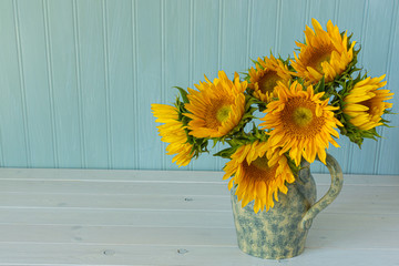 Sunflowers. Summer bouquet in crockery with pastel background.