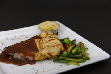 Chicken Fillet Steak Grilled with Black Pepper Sauce served on a dish with mash potato and fresh beans