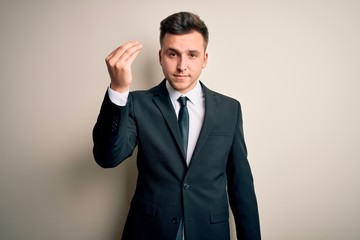 Young handsome business man wearing elegant suit and tie over isolated background Doing Italian gesture with hand and fingers confident expression