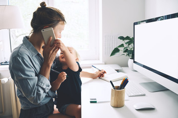 Mother working from home with little child.