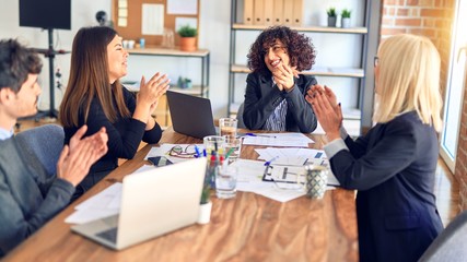 Group of business workers smiling happy and confident. Working together with smile on face applauding one of them at the office
