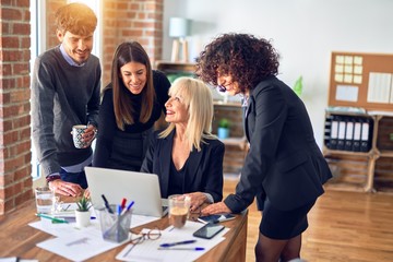 Group of business workers smiling happy and confident. Working together with smile on face  using laptop at the office
