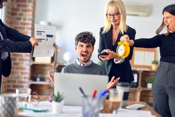 Group of business workers working together. Partners stressing one of them at the office