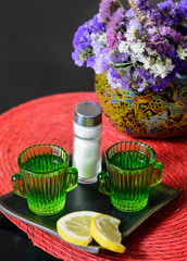 Two shot of tequila on a plate with lemon and salt
