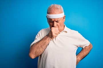 Middle age hoary sportsman doing sport wearing sportswear over isolated blue background feeling unwell and coughing as symptom for cold or bronchitis. Health care concept.