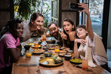 Group of young students making funny faces, taking selfies with