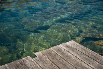 beautiful lagoon with clear water, moss rocks and green foliage in the background 
