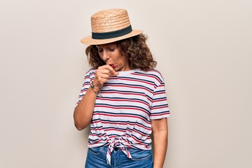 Middle age beautiful woman wearing striped t-shirt and hat over isolated white background feeling unwell and coughing as symptom for cold or bronchitis. Health care concept.