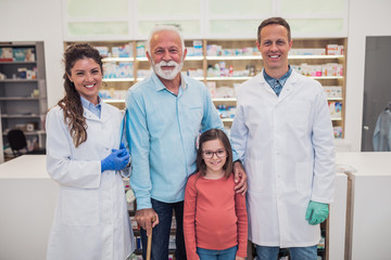 Obraz premium Professional pharmacists posing with customers in modern drugstore.