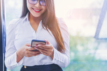 Fototapeta premium Crop image of Young smiling business woman using smartphone. selected focus