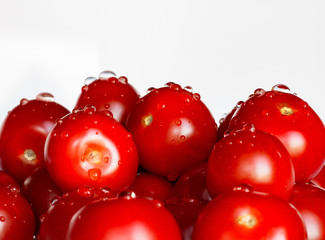Appetizing tomatoes with drops of water isolated on a white background. Copy space.