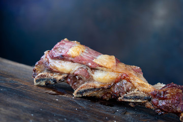 carne asada argentina sobre tabla de madera con fondo azul 