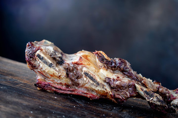 carne asada argentina sobre tabla de madera con fondo azul 