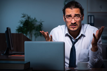 Young male employee working in the office night time