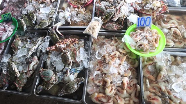 Fresh seafood at street market in Thailand. Prawns, shrimps, crabs and fish for sale 