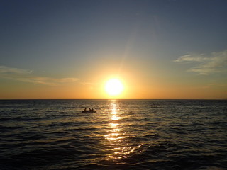 ボルネオの夕日の海を走るボート