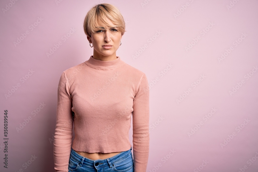 Poster Young blonde woman with short hair wearing casual turtleneck sweater over pink background skeptic and nervous, frowning upset because of problem. Negative person.