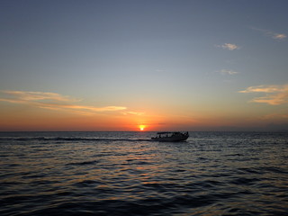 ボルネオの夕日の海を走るボート