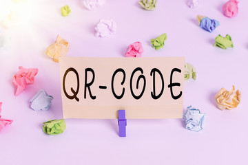 Conceptual hand writing showing Qr Code. Concept meaning the trademark for a type of matrix barcode A machinereadable code Colored crumpled paper empty reminder white floor clothespin