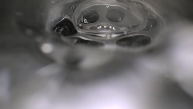 Water flowing down the drain, macro shot with prob lens