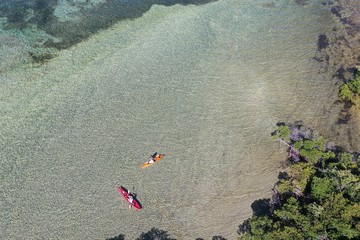 Key Biscayne, Florida - May 5, 2020 - Young couple enjoys afternoon of kayaking on calm, clear...