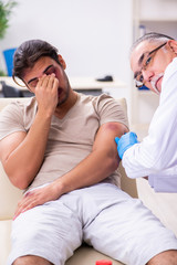 Young face injured man visiting experienced male doctor traumato