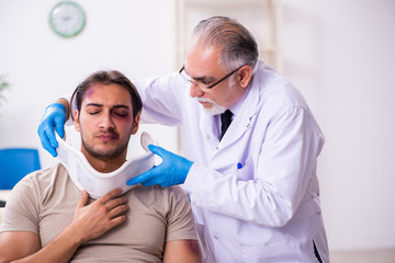 Young face injured man visiting experienced male doctor traumato