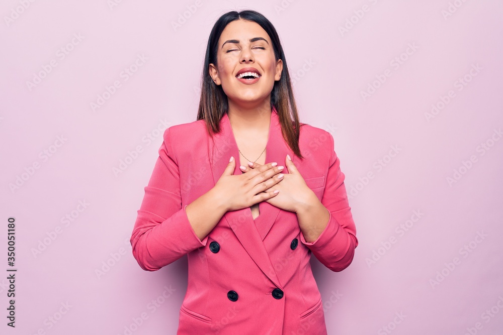 Sticker young beautiful business woman wearing elegant jacket standing over pink background smiling with han