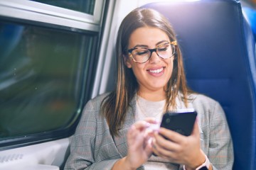 Young beautiful woman smiling happy and confident. Sitting with smile on face using smartphone...