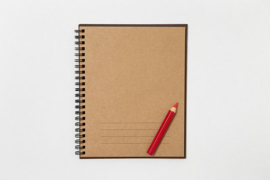 blank photo album and a red pencil. brown color paper. isolated.