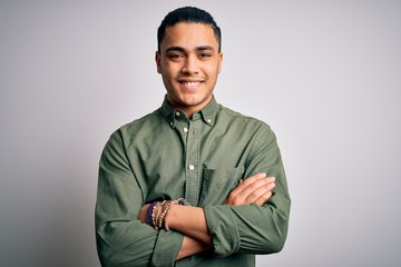 Young brazilian man wearing casual shirt standing over isolated white background with a happy and...