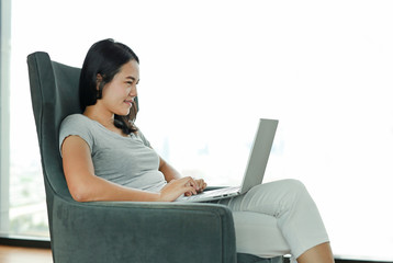 Beautiful asian woman using laptop computer working online at home.