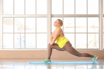 Fototapeta premium Woman with excess weight training in gym