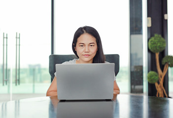 Beautiful asian woman using notebook computer on desk to working online at home.