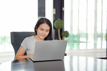 Young asian woman using laptop computer working online at home and feel relaxing. People during the...