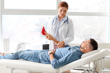 Gastroenterologist examining man in clinic