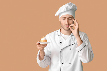 Male confectioner with tasty dessert on color background