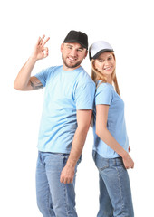Young couple in stylish caps showing OK gesture on white background